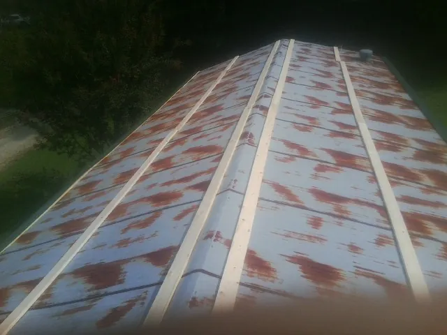 Rusted metal roof panels with new wood purlins before replacement — Storm Damage Roof Repair in Catoosa by Roofing Brothers