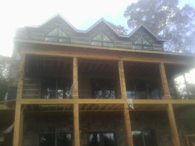 Dormers and porch framing on a large log home under construction — Roof Coating work by our crew in Catoosa