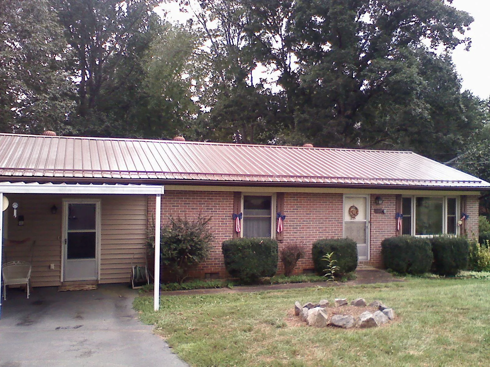 Bronze metal roof and carport on a brick ranch home — Roof Repair work by our crew in Catoosa