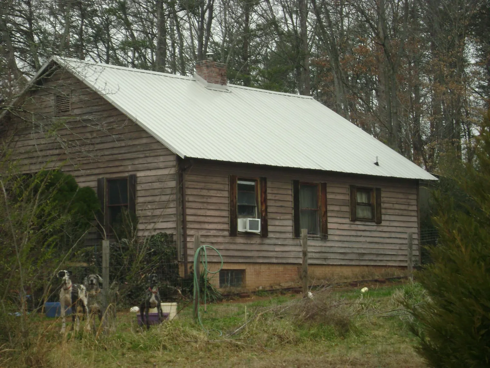 White metal roof on an old wood sided farmhouse, from a Metal Roof Installation job in Catoosa